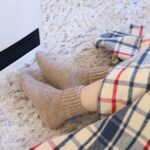 ストーブで足を温める人