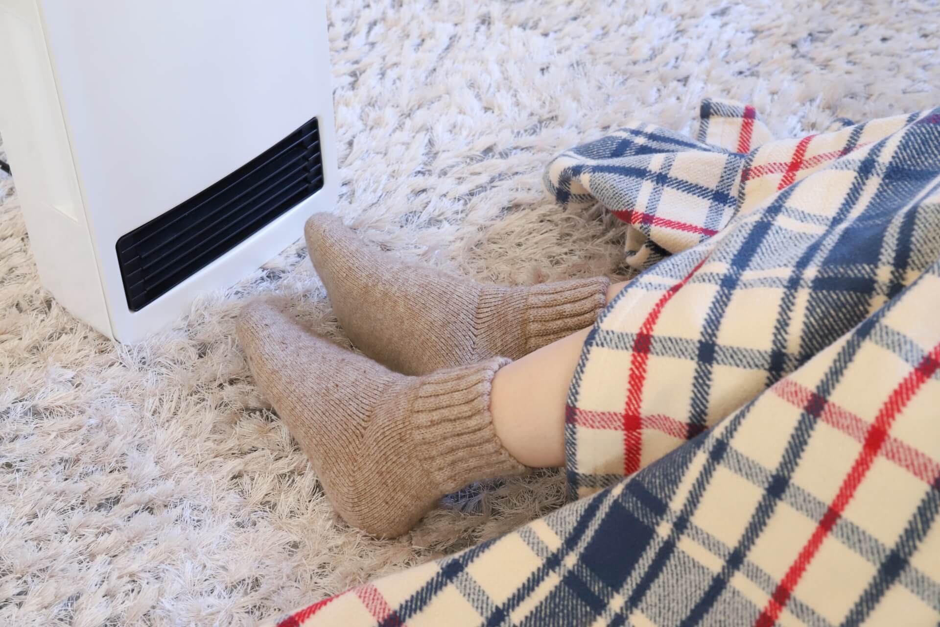 ストーブで足を温める人